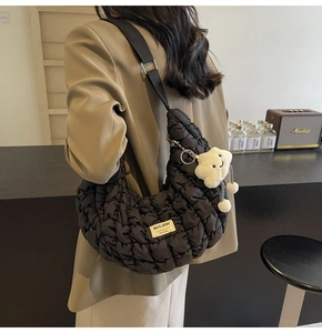 Détail du sac matelassé noir avec bandoulière réglable et pendentif nuage blanc