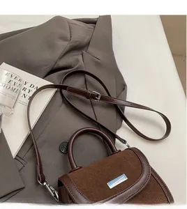 Détail de la bandoulière réglable et texture du sac selle vintage en daim et cuir