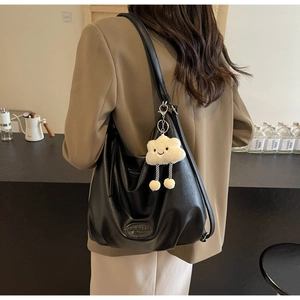 Détail d'un sac cabas en cuir souple noir avec breloque nuage dans un cadre de vie réel