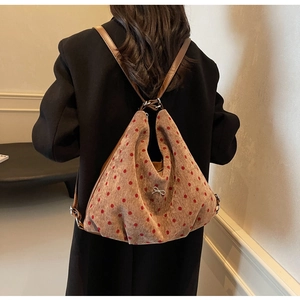 Close-up of brown corduroy backpack with red polka dots and metallic bow detail