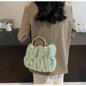 Detail of light green faux fur bag with pearl rhinestone handle and metal chain