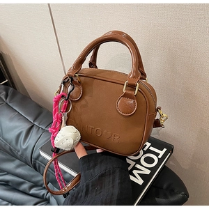 Gros plan du mini sac à main rétro marron avec texture cuir et détail de breloque