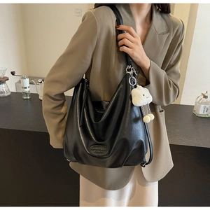 Détail du sac hobo en similicuir noir avec logo embossé et charm nuage blanc mignon