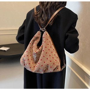 Close-up of polka dot corduroy tote bag featuring a metallic bow and leather straps