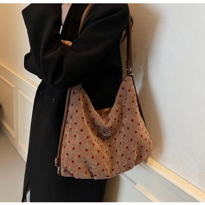 Polka dot wool tote bag with silver bow accent and brown leather straps on model