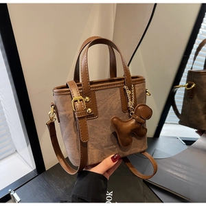 Detailed macro view of vintage brown textured bucket bag with leather handles and gold hardware