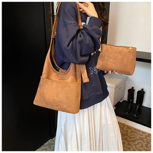 Detail view of retro caramel brown suede tote bag and matching clutch set on model