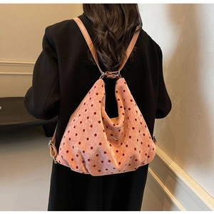Close-up of pink polka dot backpack with silver bow detail and adjustable straps