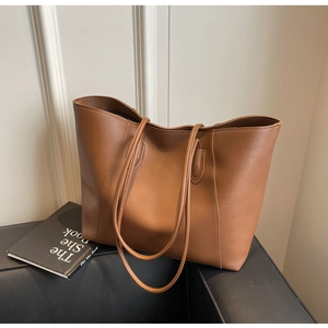 Detailed close-up of brown minimalist faux leather tote bag with smooth matte finish