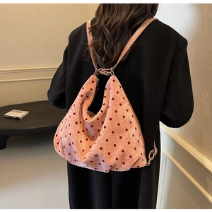 Detailed back view of pink polka dot hobo bag with a delicate metallic bow charm