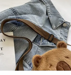 Detail of adjustable brown woven shoulder strap on Capybara plush crossbody bag