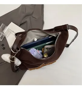 Vista interna che mostra la grande capacità della borsa scamosciata marrone con accessori
