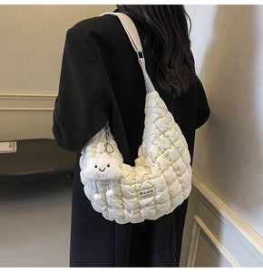 Détail du sac hobo matelassé blanc avec breloque nuage et étiquette MULAIDI sur l'épaule
