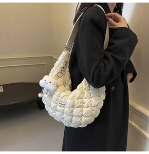 Détail d'un sac à bandoulière matelassé blanc avec sangle réglable et pendentif nuage