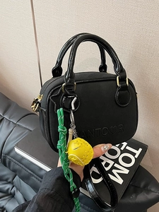 Minimalist black leather crossbody bag with star hook and yellow pompom detail