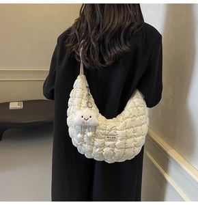 Détail du sac demi-lune blanc matelassé avec un charm nuage en peluche et texture douce