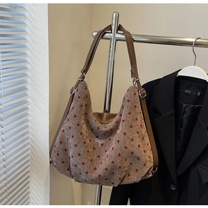 Close-up of brown wool tote bag featuring red polka dots and silver bow buckle