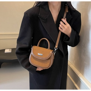 Détail de la sacoche marron montrant le mélange de cuir lisse et de daim premium