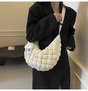 Détail du sac bandoulière matelassé avec pendentif nuage en peluche et bandoulière