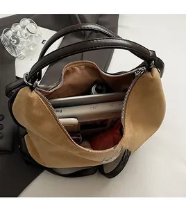 Vista dall'alto dell'ampio interno della borsa in pelle scamosciata marrone con accessori