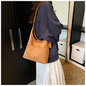 Vintage brown faux suede bucket tote bag shown with model in home interior setting