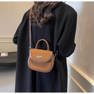 Détail du sac de selle marron en cuir mélangé avec logo et garnitures argentées
