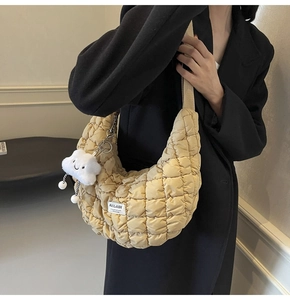 Vue détaillée du sac matelassé jaune avec pendentif nuage et étiquette de marque