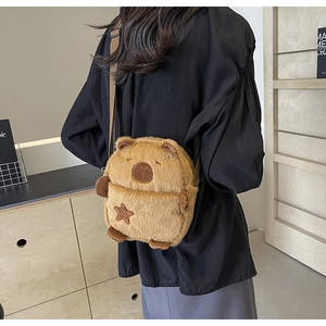 Detail of Capybara plush crossbody bag with star patch embroidery shown on model