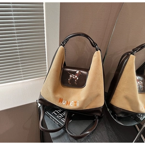 Dettaglio della borsa hobo in camoscio cammello con ricamo e rifiniture in pelle