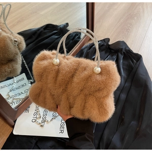Close-up of brown faux fur bag featuring rhinestone handles and pearl accents