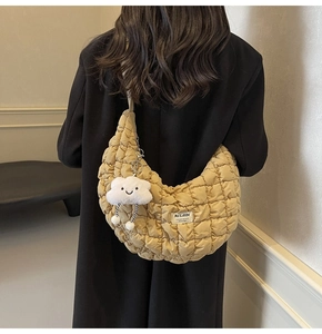 Détail d'un sac demi-lune matelassé kaki avec un charm nuage blanc et une large bandoulière