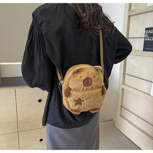 Close-up of fluffy Capybara plush crossbody bag with star patch and brown strap details