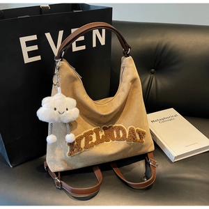 Dettaglio borsa hobo in pelle scamosciata kaki con patch HOLIDAY e ciondolo a nuvola