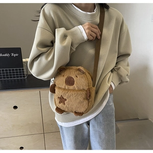 Close-up of brown plush bear crossbody bag with star embroidery and textile strap