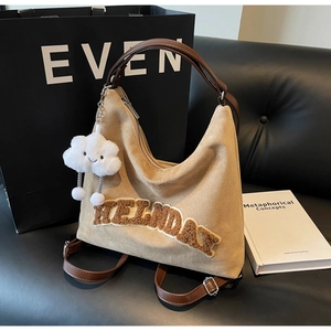 Dettaglio borsa tote in pelle scamosciata con ricamo HOLIDAY e ciondolo nuvola