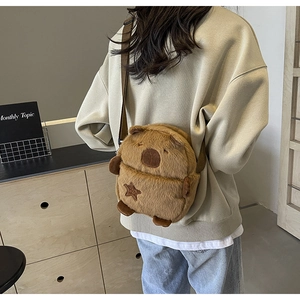 Close-up of plush capybara crossbody bag with adjustable strap worn by a model