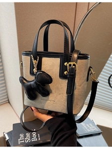 Chic two-tone canvas tote bag with black leather straps and cute puppy charm accessory
