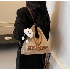 Dettaglio borsa tote in pelle scamosciata kaki con ricamo HELLO e ciondolo a nuvola