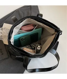 Top view of large black glossy tote bag interior showing ample space and compartments