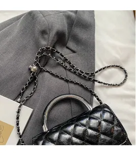 Détail du sac en cuir noir matelassé avec poignée en anneau argenté et chaîne