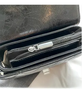 Détail de la fermeture éclair argentée et des compartiments internes du sac noir