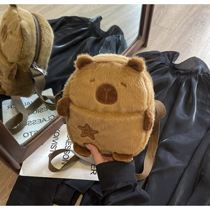 Close-up of brown plush capybara bag with embroidered star and capy bara text detail