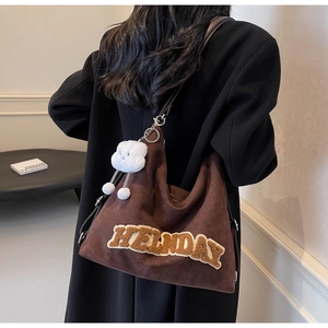 Dettaglio della borsa tote in shearling marrone con ricamo Helnday e ciondolo a nuvola