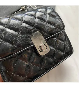 Détail du sac en cuir matelassé noir brillant avec fermoir rotatif en métal argenté