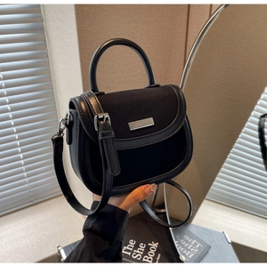 Détail du sac besace noir montrant le rabat en daim et la bandoulière réglable