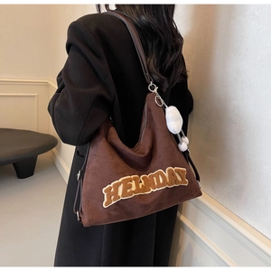 Dettaglio borsa tote vintage in pelle scamosciata marrone con ricamo HELLNDAY e pompon