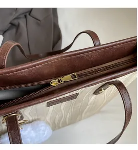 Détail de la fermeture éclair dorée lisse et de la texture d'un grand sac fourre-tout