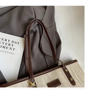 Détails du cabas en toile beige à chevrons avec poignées en cuir marron et rivets dorés