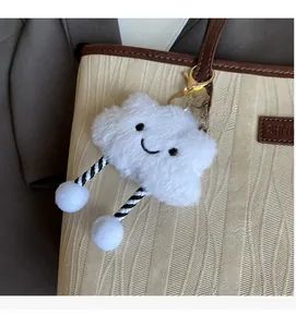 Gros plan détaillé d'un accessoire de sac en peluche blanche en forme de nuage brodé