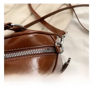 Detailed macro view of smooth brown leather texture and silver metal zipper hardware